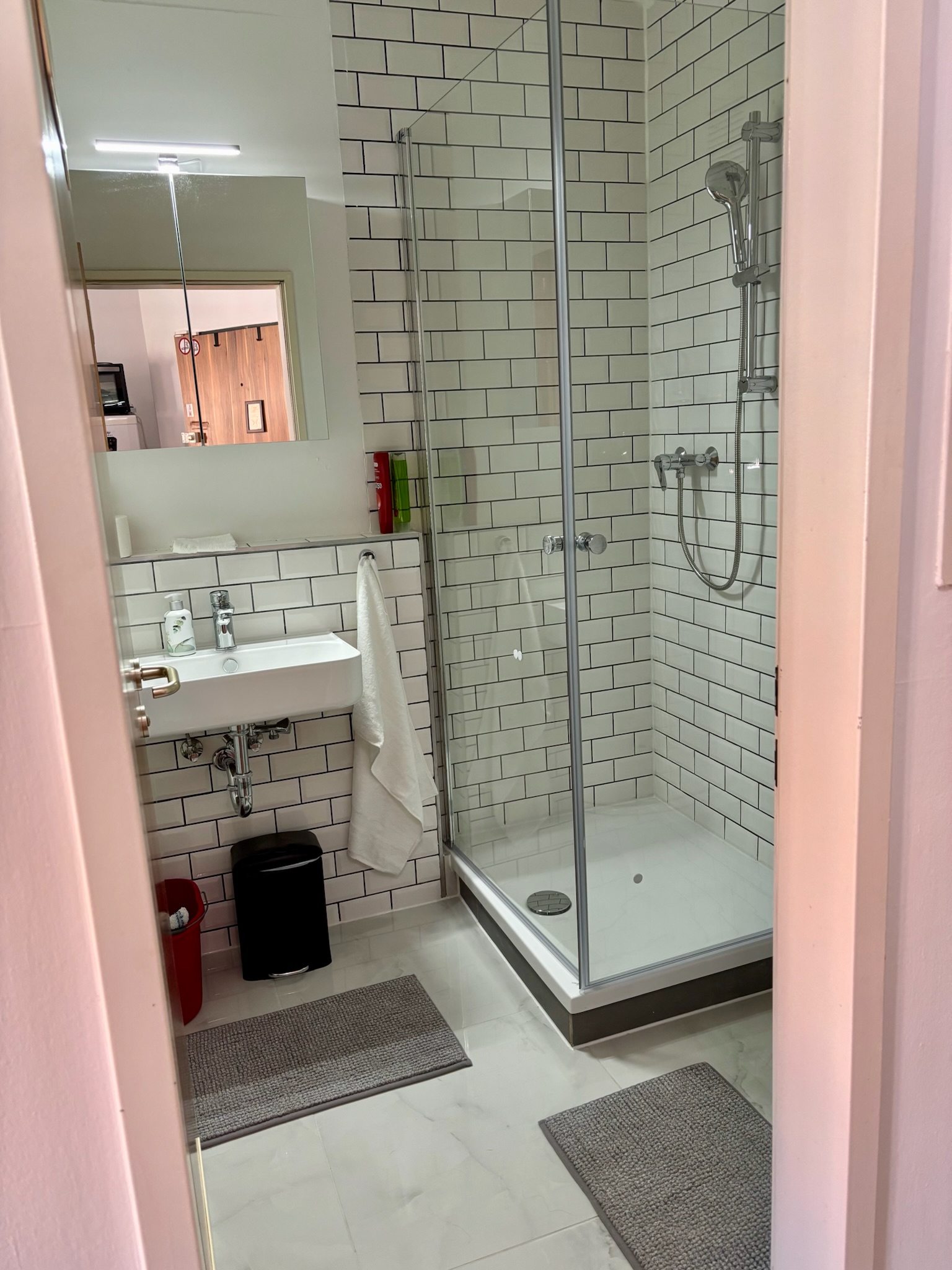 Grand Studio bathroom with green fixtures and subway tiles