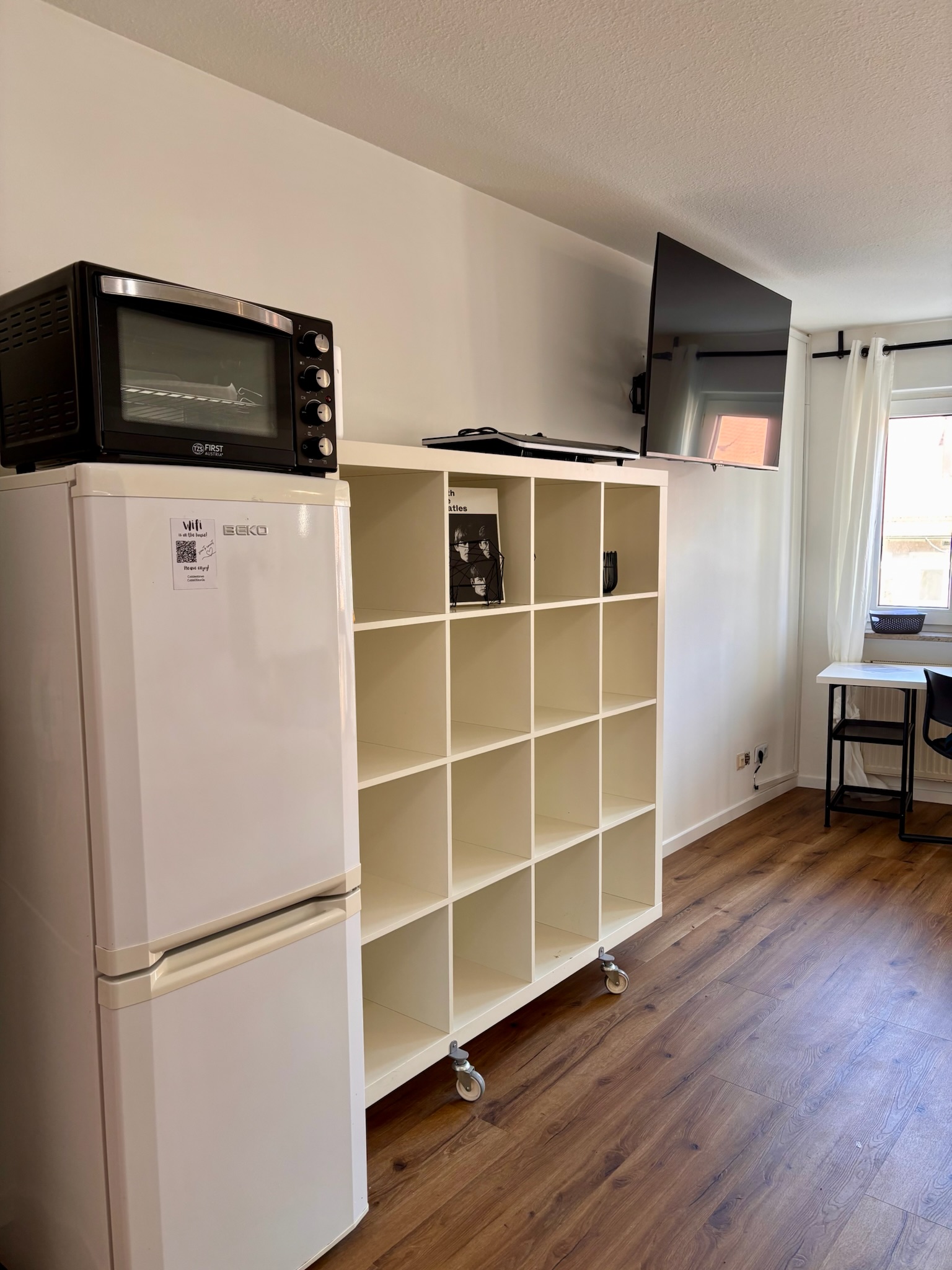 Grand Studio kitchenette with white cabinetry and appliances